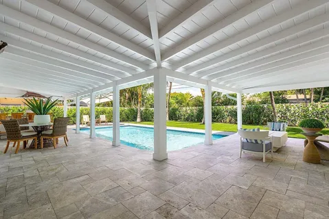 a view of a swimming pool with a garden and palm trees