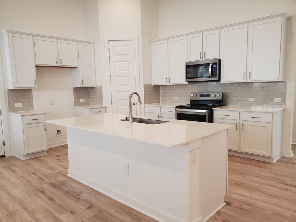 648 Peace Pipe Way Georgetown, TX 78628 - Photo 3 of 12 a kitchen with stainless steel appliances a sink a stove a microwave and cabinets