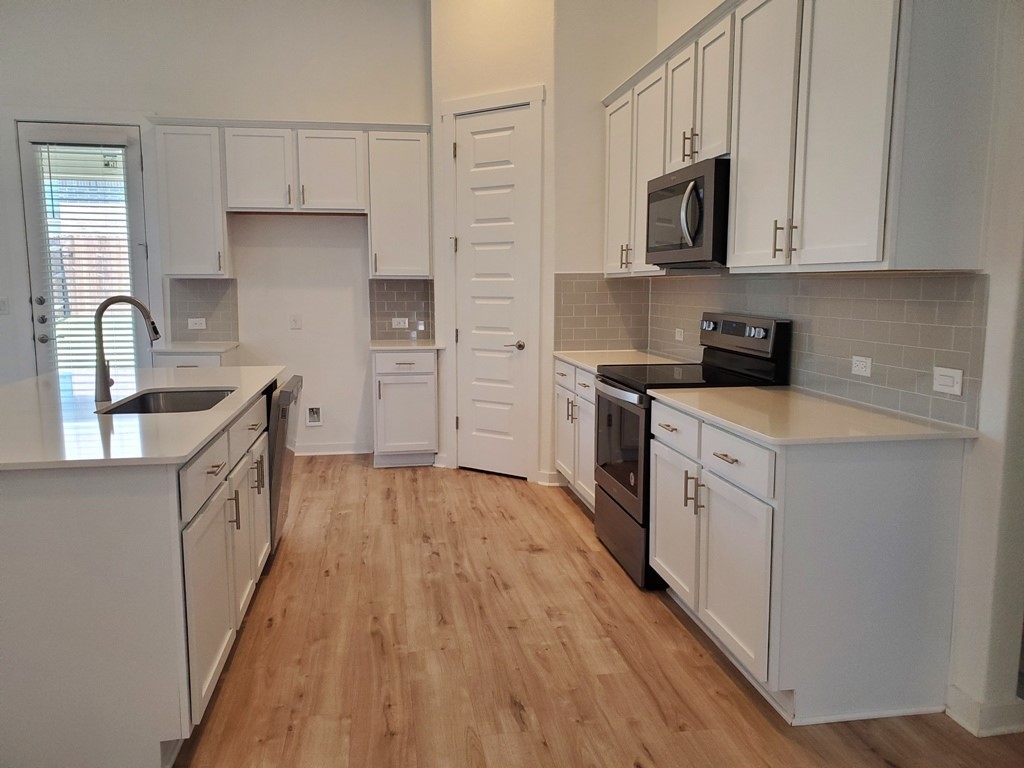 648 Peace Pipe Way Georgetown, TX 78628 - Photo 6 of 12 a kitchen with kitchen island granite countertop a sink and steel appliances