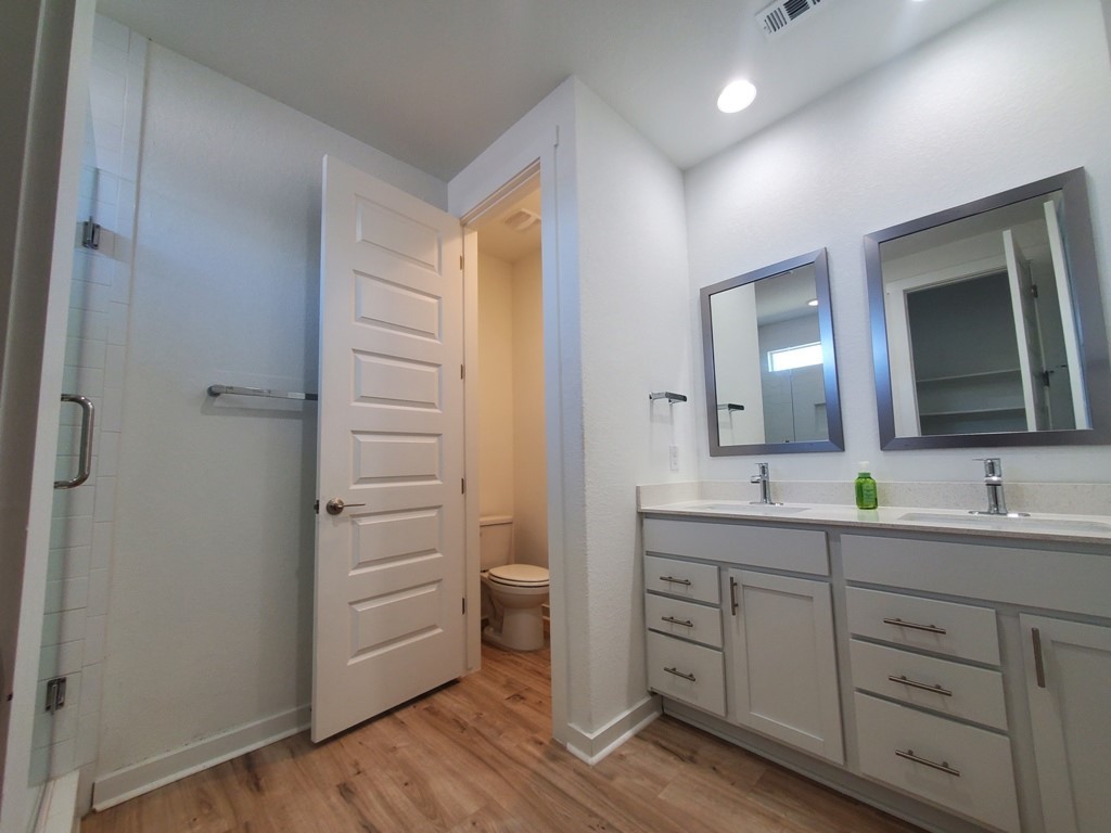 648 Peace Pipe Way Georgetown, TX 78628 - Photo 7 of 12 a bathroom with a double vanity sink a mirror and a shower