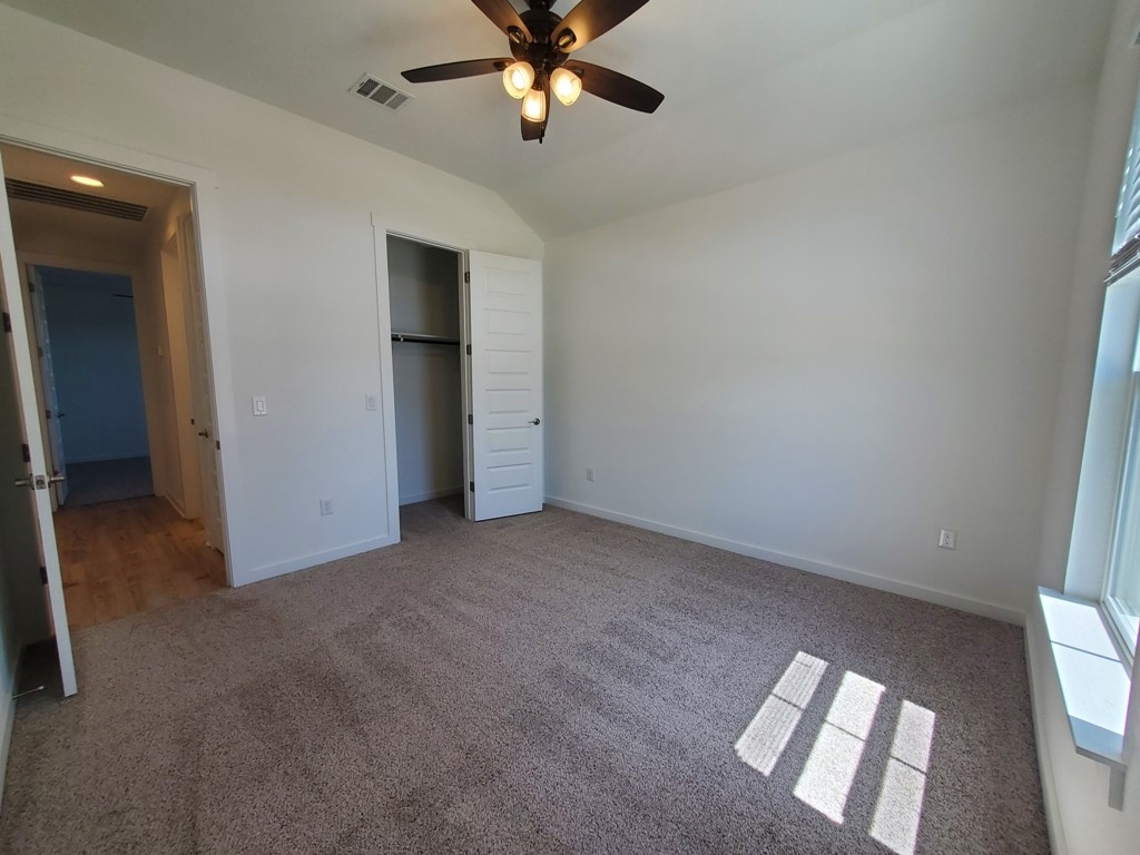 648 Peace Pipe Way Georgetown, TX 78628 - Photo 8 of 12 an empty room with closet and a chandelier fan
