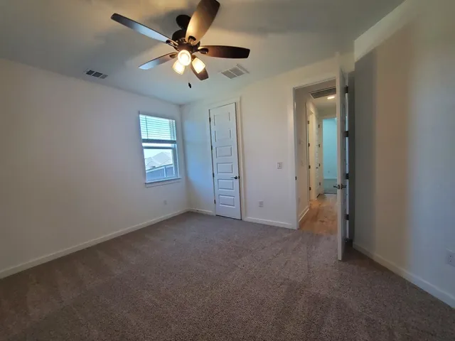 an empty room with fan and windows