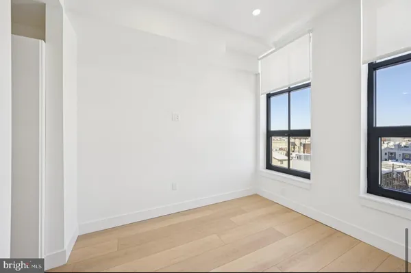 an empty room with windows and closet