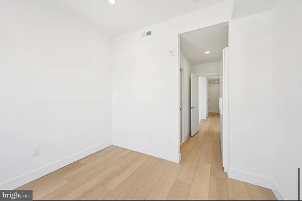 a view of a room with wooden floor and a hallway
