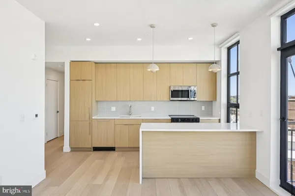 a view of a kitchen with stainless steel appliances granite countertop a stove a sink and a microwave