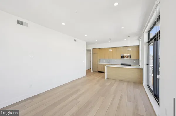 a large kitchen with a wooden floor and a large window