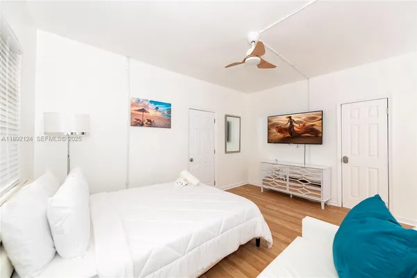 a bedroom with a bed window and wooden floor