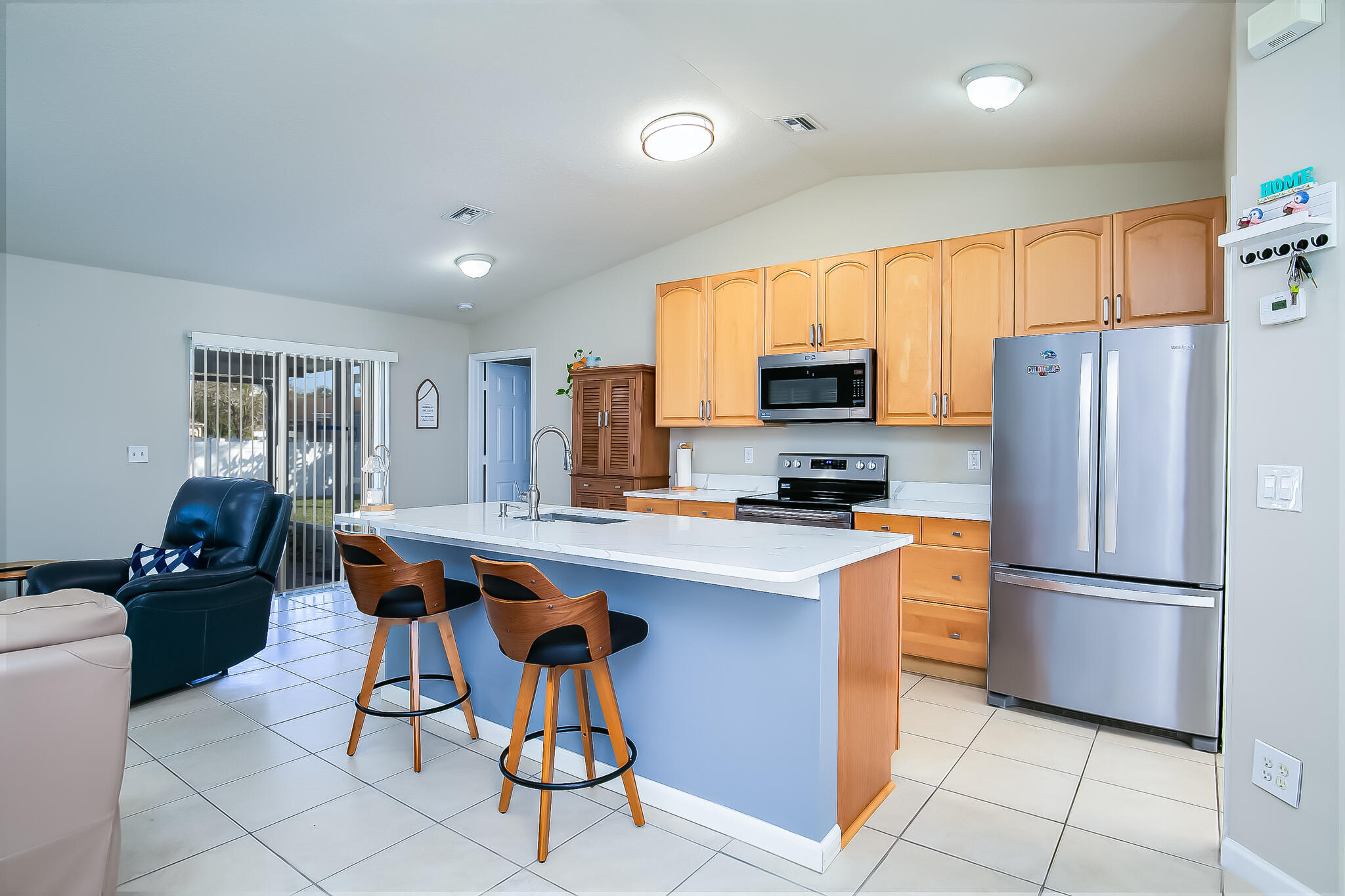 2065 Southwest Gemini Lane Port St. Lucie, FL 34984 - Photo 12 of 24 a kitchen with stainless steel appliances a refrigerator a stove a sink a dining table and chairs