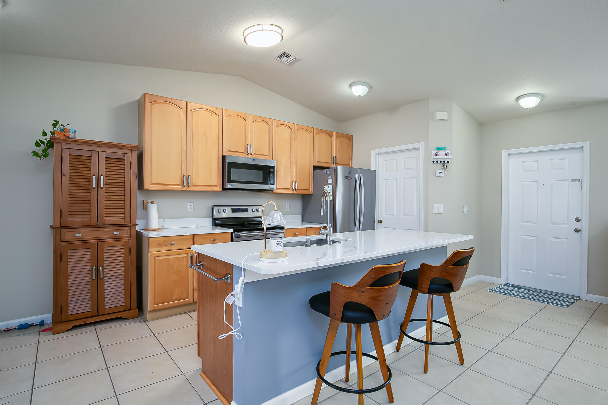 2065 Southwest Gemini Lane Port St. Lucie, FL 34984 - Photo 13 of 24 a kitchen with stainless steel appliances a refrigerator stove microwave and cabinets