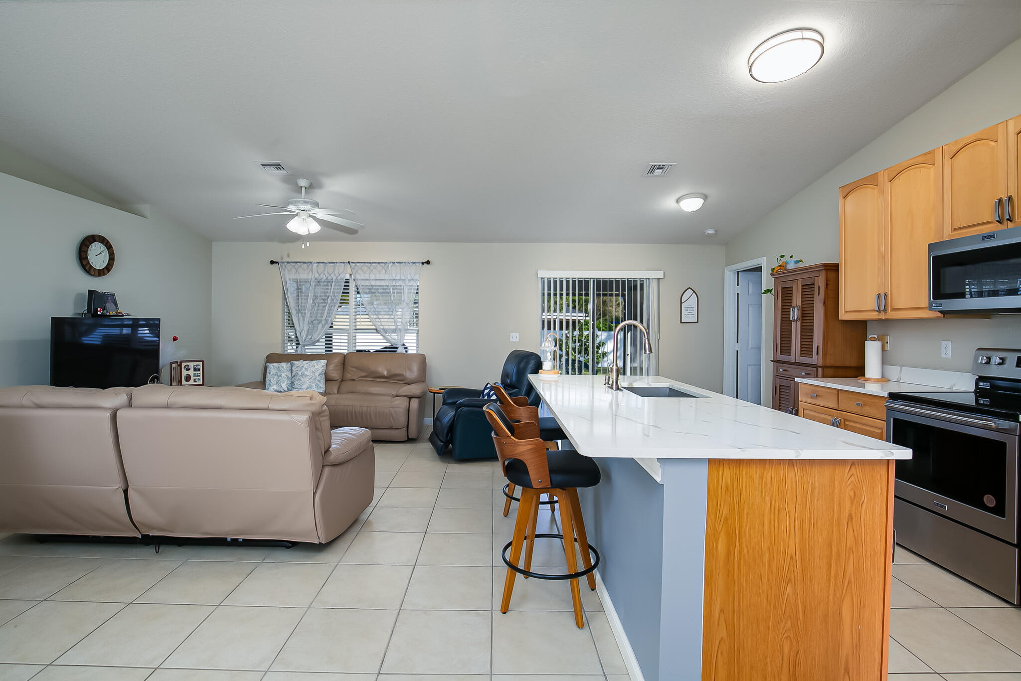 2065 Southwest Gemini Lane Port St. Lucie, FL 34984 - Photo 7 of 24 a living room with furniture and a dining table with kitchen view