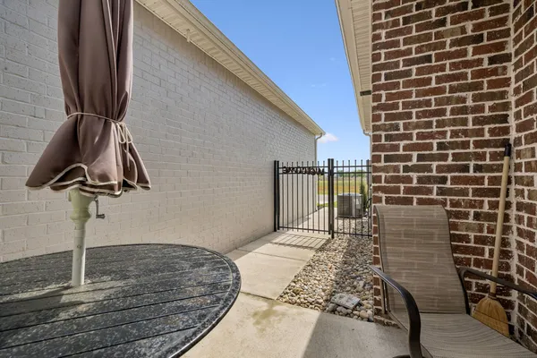 a view of a brick house with table and chairs