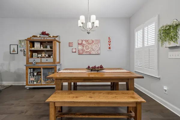 a living room with a table chairs and a chandelier