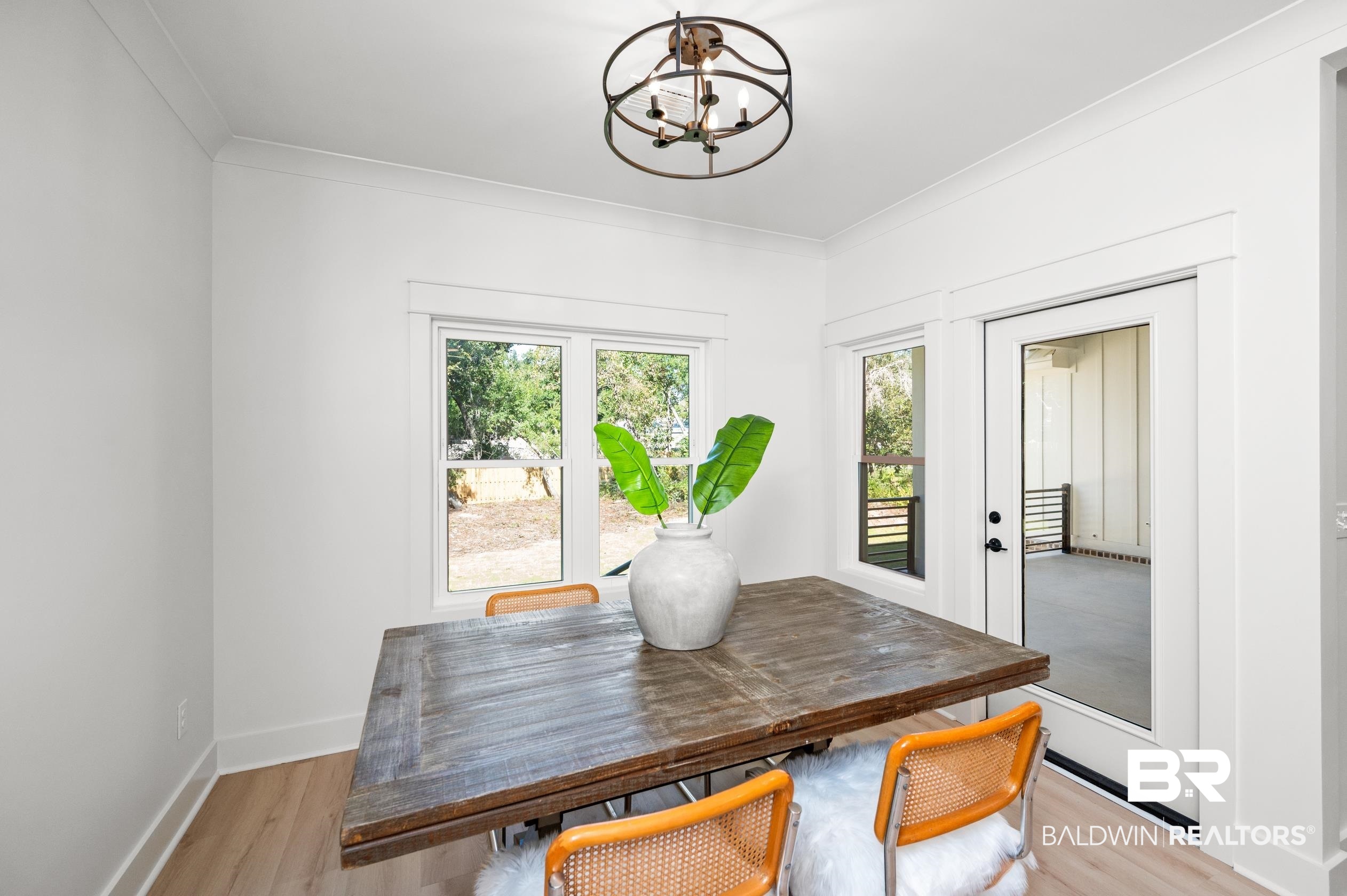 28889 Canal Road Orange Beach, AL 36561 - Photo 13 of 55 Dining space with a chandelier, light wood-type flooring, and crown molding