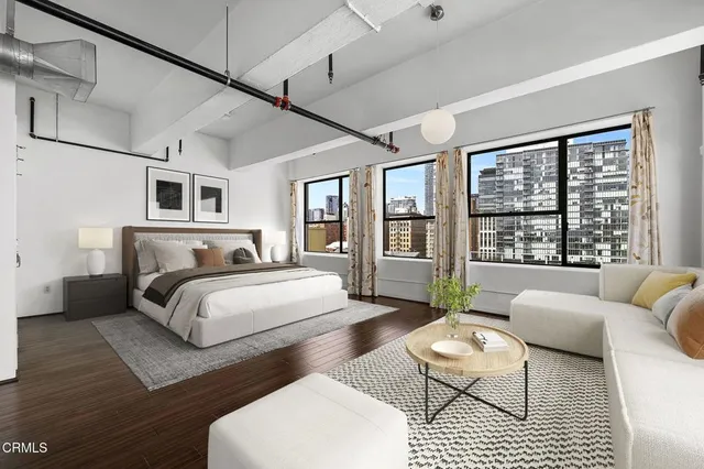 a spacious bedroom with a bed a couch and a large window