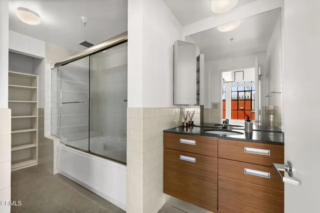a bathroom with a shower sink and mirror
