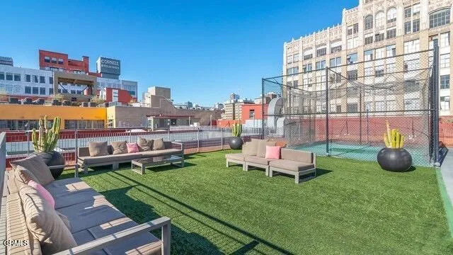 a view of a living room with couches potted plants and swimming pool