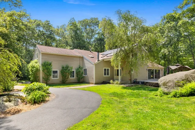 a front view of a house with a yard and trees