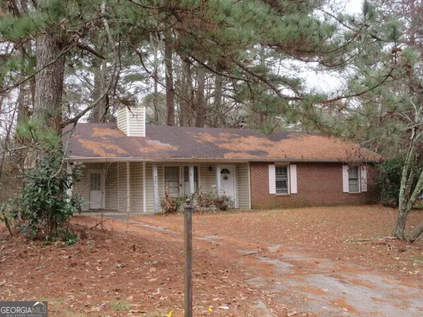 a front view of a house with yard tree and wooden fence