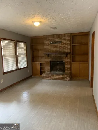a view of empty room with a fireplace
