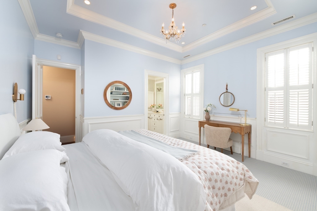 304 Commonwealth Avenue, Unit PH Boston, MA 02115 - Photo 29 of 42 a bedroom with a bed and a chandelier