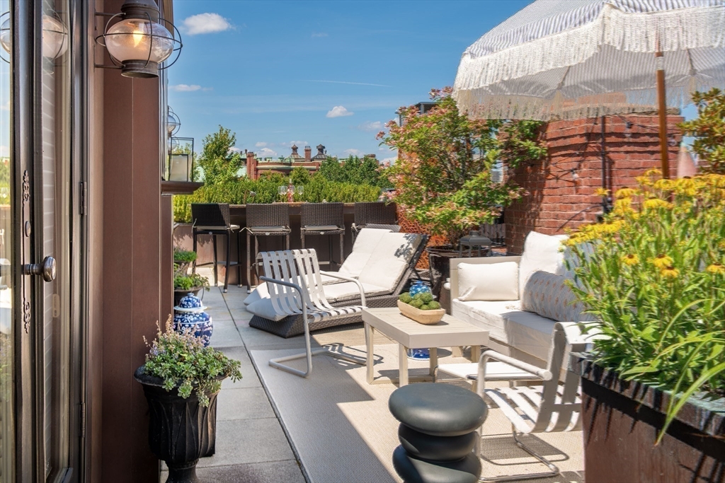 304 Commonwealth Avenue, Unit PH Boston, MA 02115 - Photo 38 of 42 a view of a patio with table and chairs potted plants