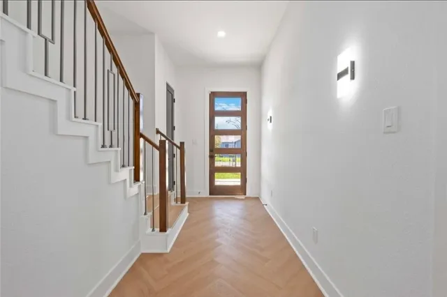 a view of a hallway with wooden staircase