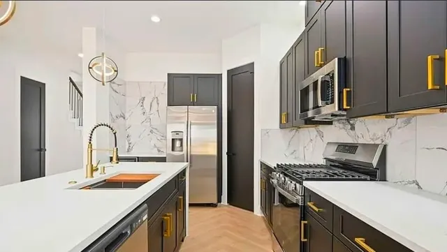 a kitchen with stainless steel appliances granite countertop a sink stove and refrigerator