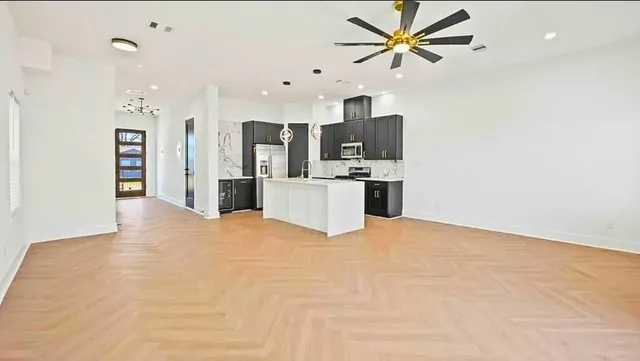 a view of a kitchen with a sink and a refrigerator