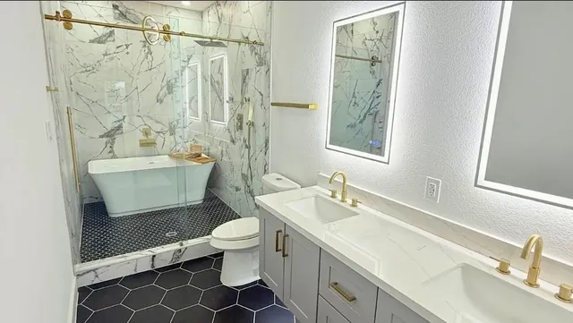 a bathroom with a sink a toilet and shower