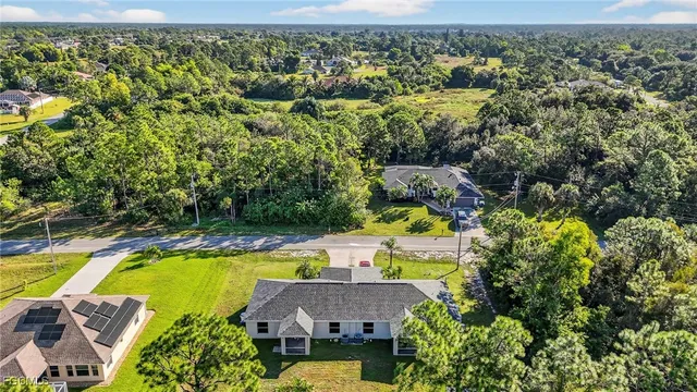 an aerial view of house with swimming pool and garden