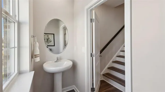 a bathroom with a sink a mirror a lamp and window