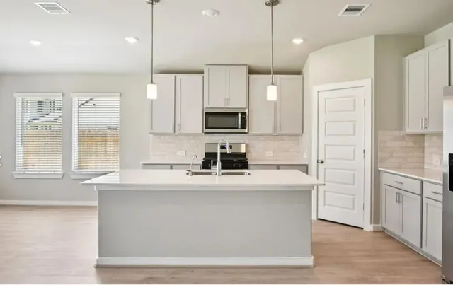 a kitchen with kitchen island white cabinets and stainless steel appliances