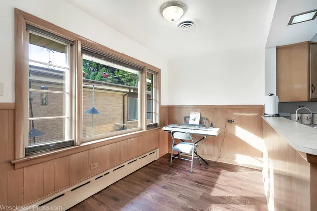 a workspace with wooden floor and a large window
