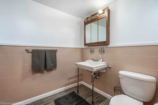 a bathroom with a toilet a sink and mirror