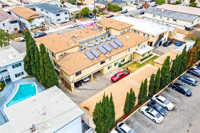 an aerial view of residential houses with outdoor space and parking