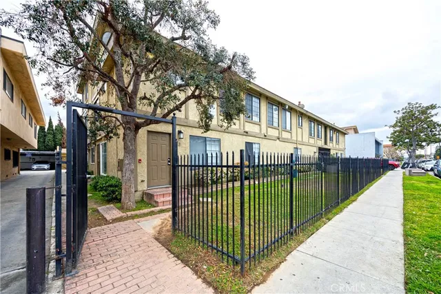 a view of residential houses with yard and wooden fence