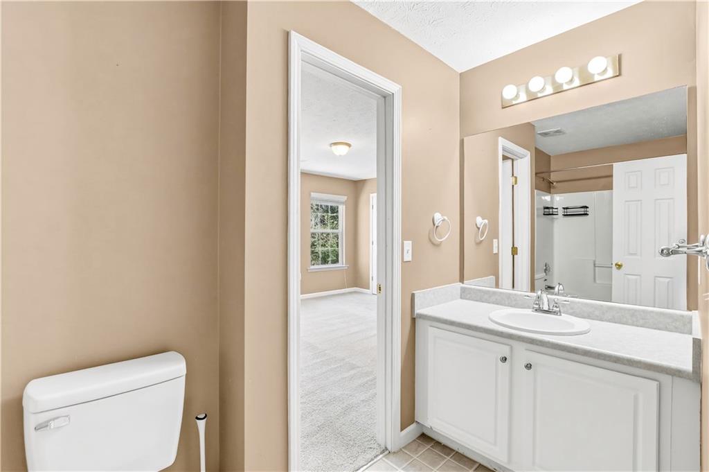 5976 Bowers Road Stone Mountain, GA 30087 - Photo 21 of 31 a bathroom with a granite countertop sink mirror and toilet