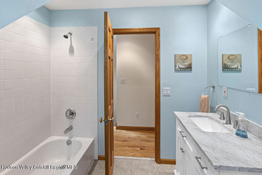 10 Old Farm Road Shokan, NY 12481 - Photo 54 of 68 a bathroom with a granite countertop sink a mirror and a bathtub