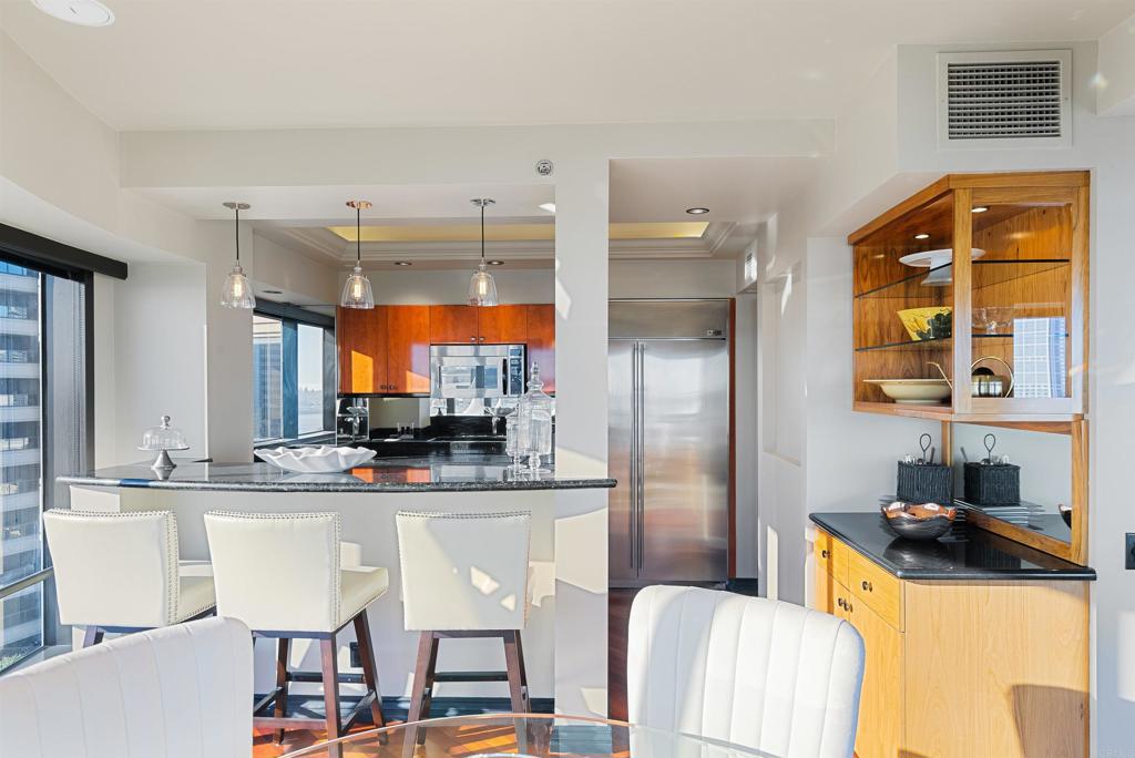 200 Harbor Drive, Unit 1502 San Diego, CA 92101 - Photo 8 of 48 a kitchen with stainless steel appliances kitchen island granite countertop a refrigerator and a stove top oven