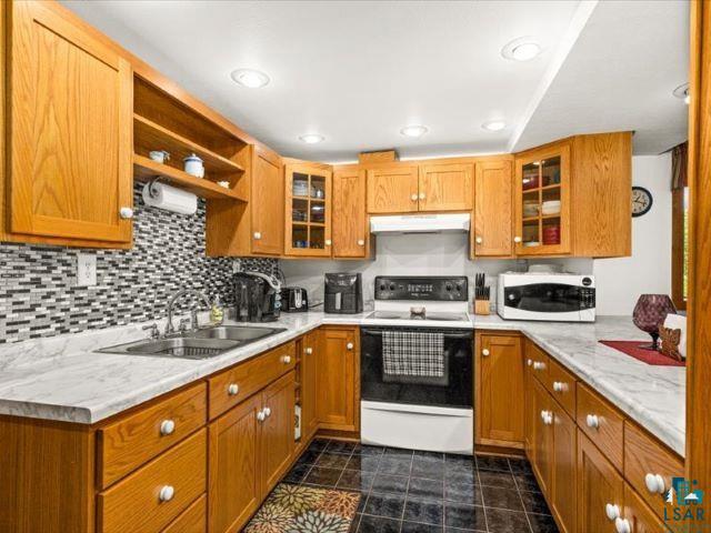 3616 Lavaque Road Hermantown, MN 55811 - Photo 41 of 43 Kitchen featuring wood cabinetry, white countertops, tile flooring, and a mosaic tile backsplash