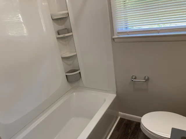 a white bath tub sitting next to a toilet