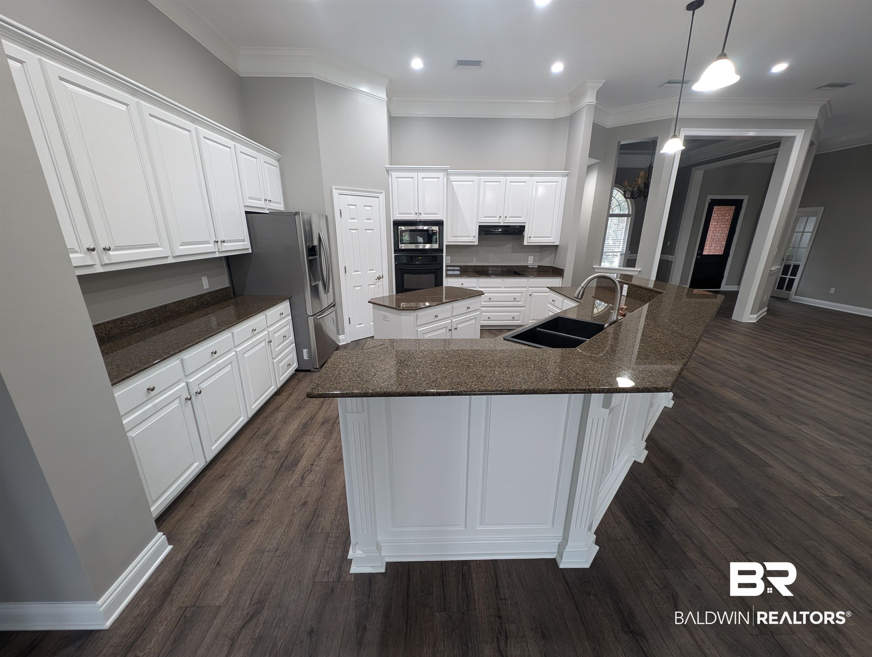 11623 Halcyon Loop Daphne, AL 36526 - Photo 22 of 90 Kitchen with white cabinets, a large island, decorative light fixtures, stainless steel appliances, and dark hardwood / wood-style floors