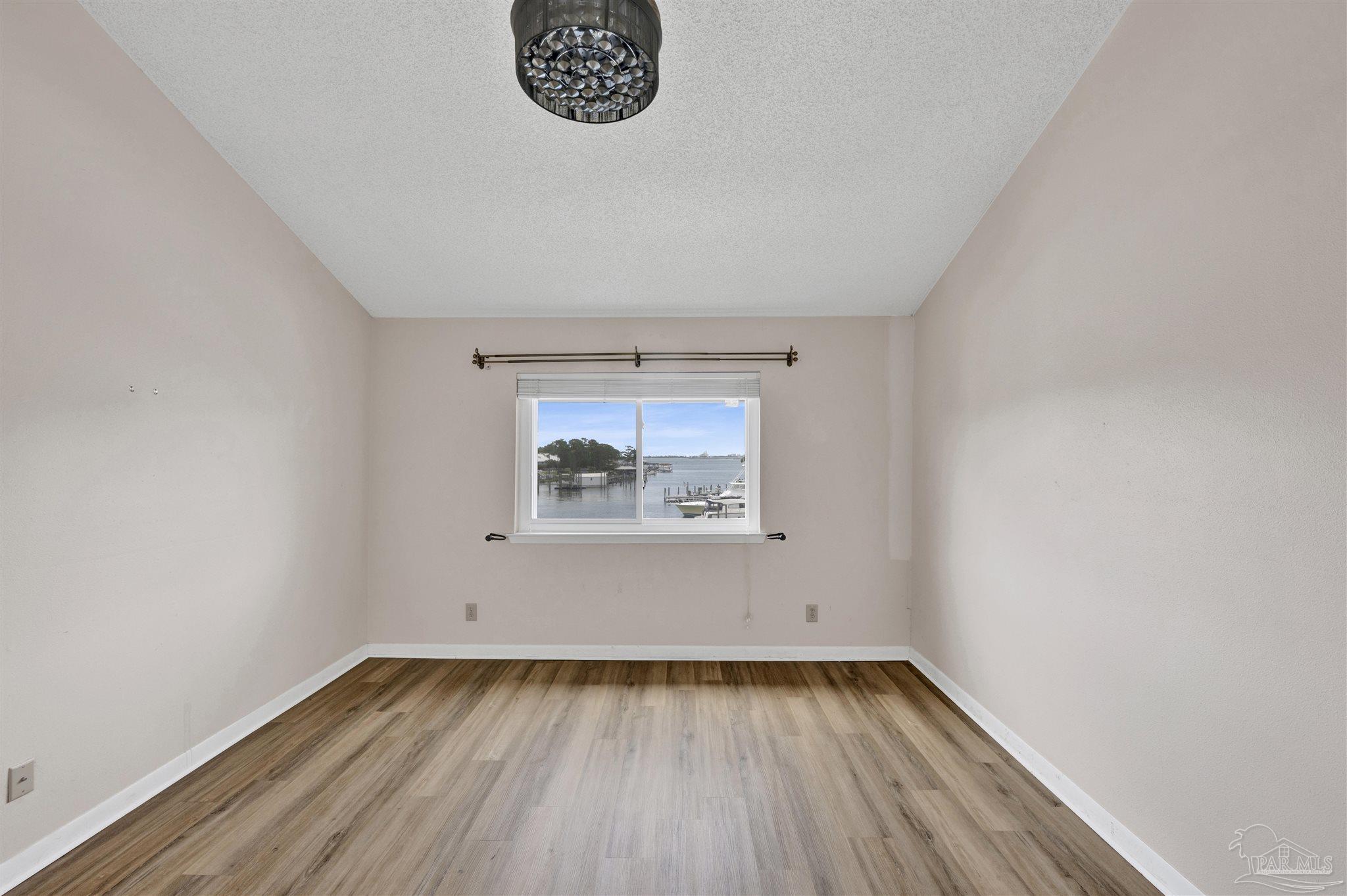 14100 River Road, Unit 334 Perdido Key, FL 32507 - Photo 18 of 35 a view of an empty room with wooden floor and a window