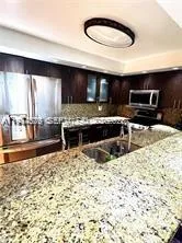 a kitchen with stainless steel appliances kitchen island granite countertop a sink and a stove