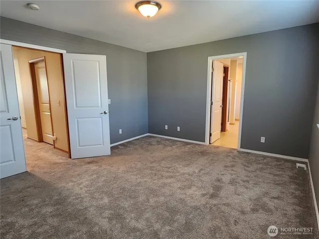 an empty room with windows and closet