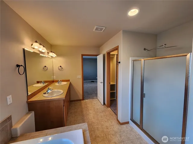 a bathroom with a sink mirror and a shower
