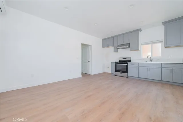 a view of a kitchen with wooden floor and stainless steel appliances