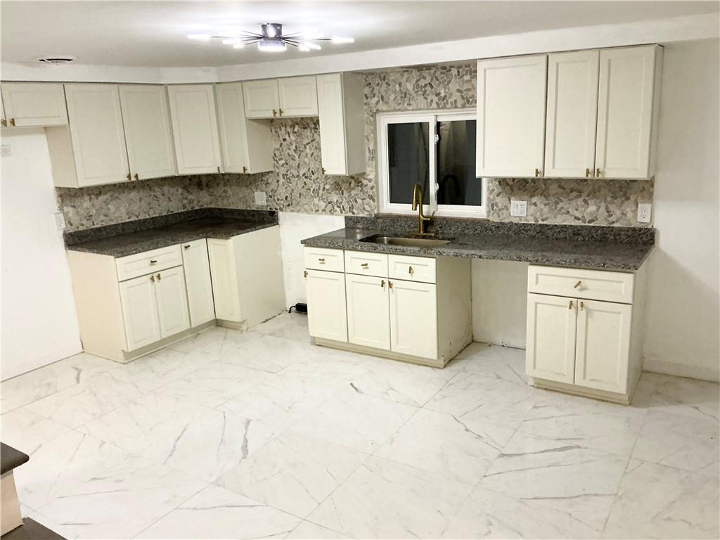 3326 Spring Garden Road Pittsburgh, PA 15212 - Photo 15 of 21 a kitchen with granite countertop a sink and white cabinets