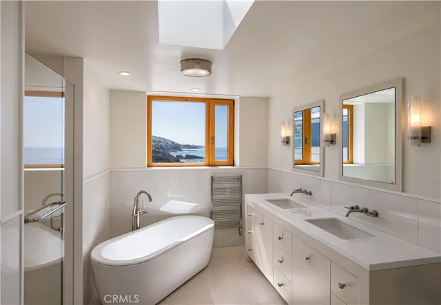 a bathroom with a double vanity sink toilet mirror and window