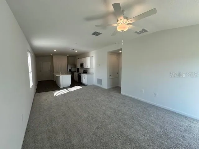 an empty room with a ceiling fan and a window